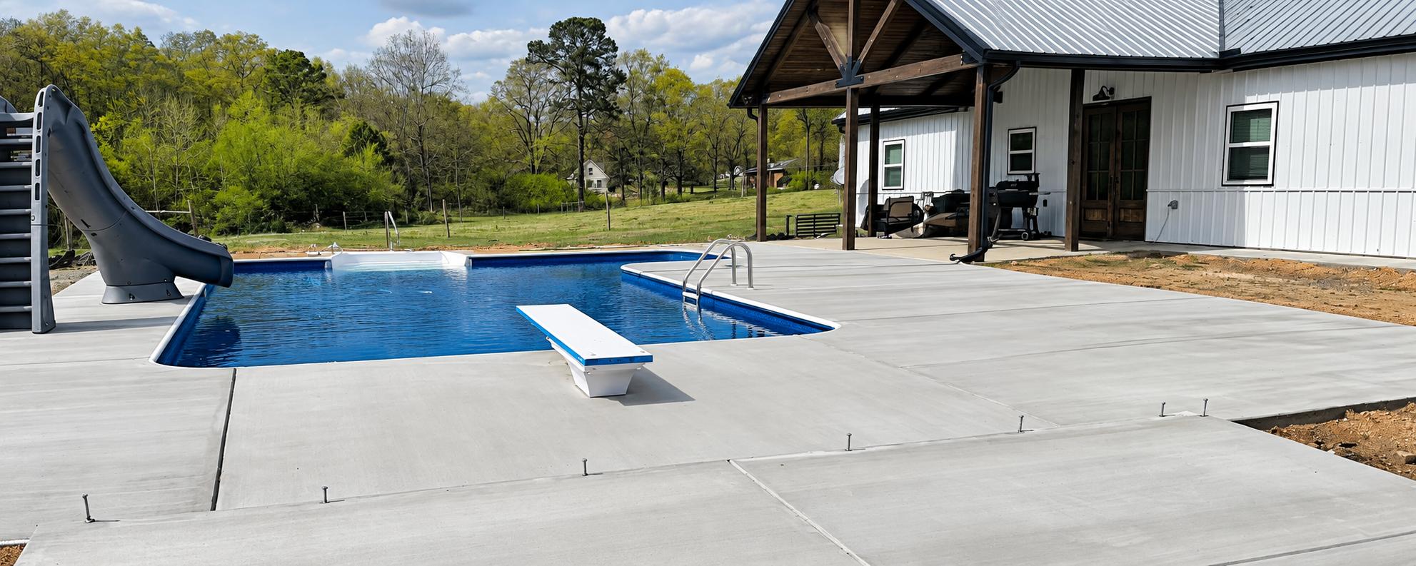 Wide concrete pool deck surrounding a swimming pool beside a covered residential porch