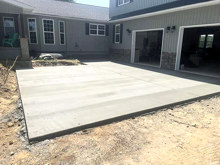 Finished backyard concrete patio beside a home