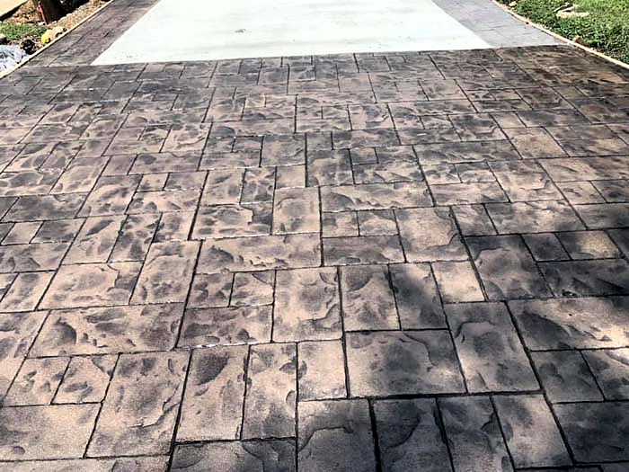 Close-up of a stone-pattern stamped concrete driveway entry